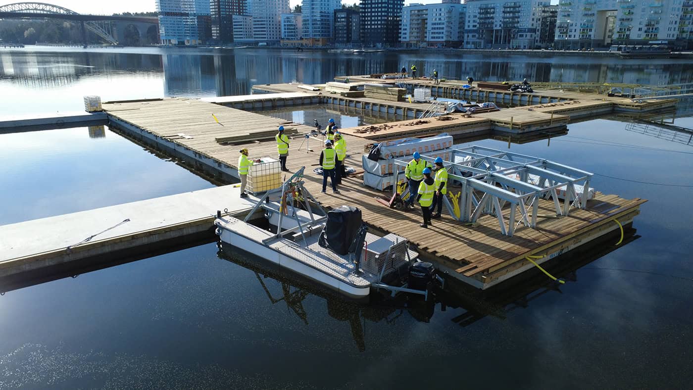 Schwimmende Dockingstation mit Mitarbeitern bei der Wartung am Wasser.