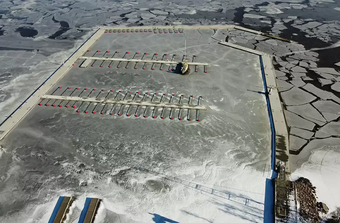 Vågbrytande pontoner i ett isigt Lövuddens hamn